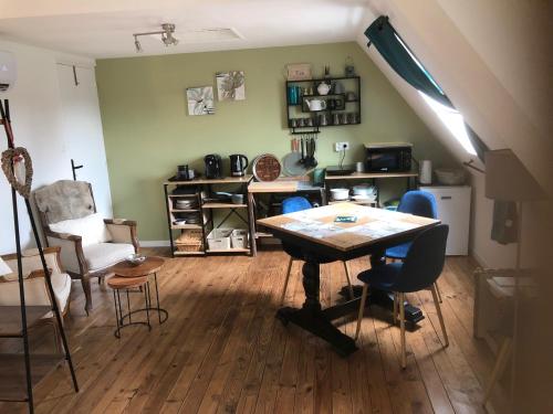 un salon avec une table et des chaises dans l'établissement Chambre studio familiale la Brandonnière, à Courson