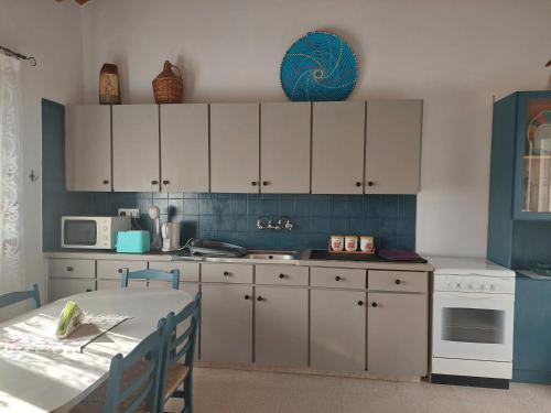 a kitchen with white cabinets and a table in it at Veranda in Agros