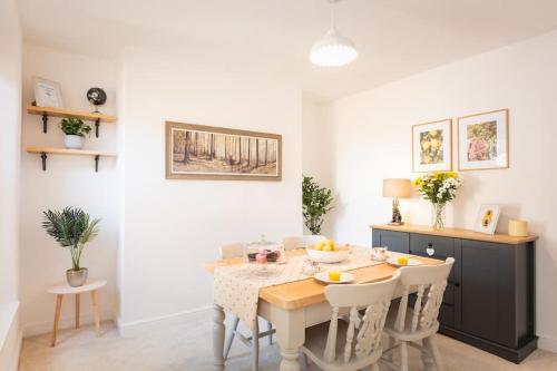 uma sala de jantar com mesa e cadeiras em *Brand New* Lemon Tree Cottage em Torquay