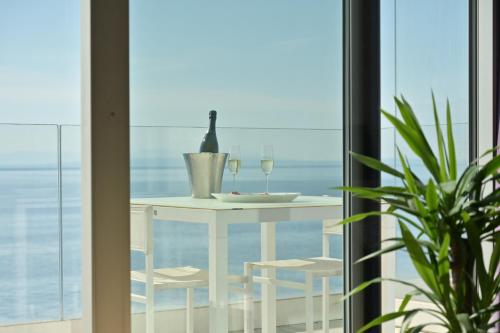 a table with two glasses of wine on a balcony at Bevanda Hotel & Restaurant - Unique Adriatic in Opatija