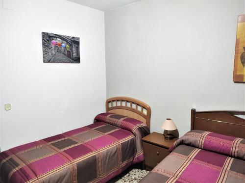 - une chambre avec 2 lits et une photo sur le mur dans l'établissement Casa Rural EL HUERTO con Jardín, à Lumbrales