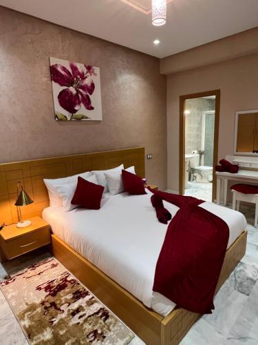 een slaapkamer met een groot bed met rode kussens bij Antonios luxury apartments in Fès