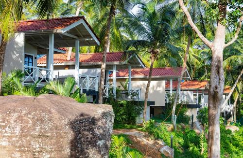 a white house with palm trees in front of it at Tabula Rasa Resort & Spa in Galle