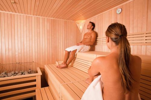 a man and woman sitting in a sauna at Aparthotel Zell am See (Contactless Check-In) in Zell am See