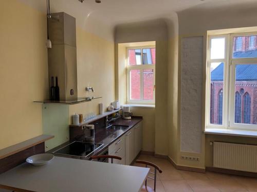 a kitchen with a counter and two windows and a table at BestHomeRiga in Riga