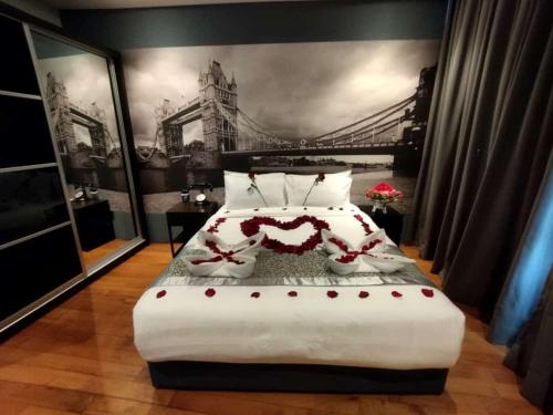a bedroom with a large bed with a bridge on the wall at The Luxury Penthouse Twin Tower view in Kuala Lumpur