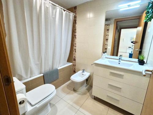 y baño con aseo, lavabo y espejo. en Duplex RIO EBRO, en Deltebre