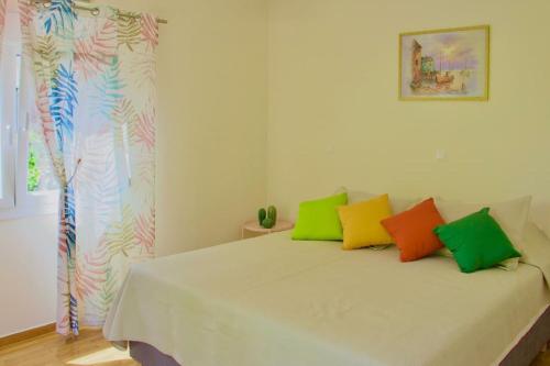 a bedroom with a bed with colorful pillows on it at Glyfada Path of Poets in Athens