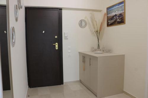 a black door in a room with a counter and a cabinet at Glyfada Path of Poets in Athens