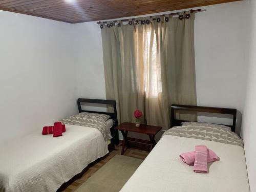 Duas camas individuais num quarto com presentes em Casa da Elena em Campos do Jordão