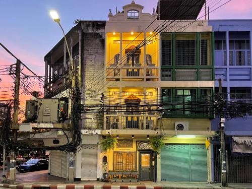 een oud gebouw met groene deuren in een stadsstraat bij Central Old Town Cottage in Bangkok