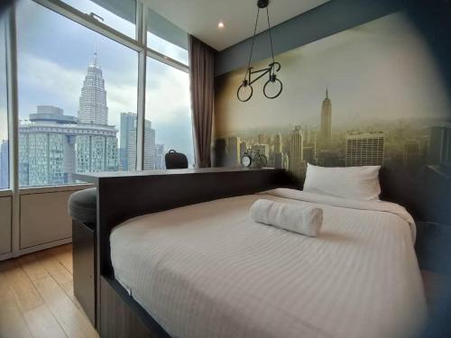 a bedroom with a bed with a view of a city at Soho Suites KLCC Kuala Lumpur in Kuala Lumpur