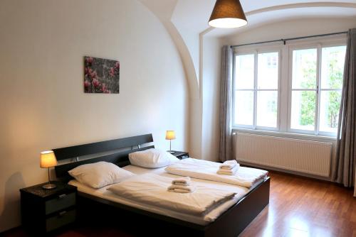 sypialnia z łóżkiem i dużym oknem w obiekcie Betlem Prague Apartments w Pradze