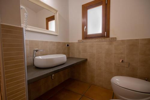 a bathroom with a sink and a toilet at Capannizza Villas in Budoni