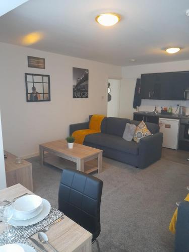 ein Wohnzimmer mit Sofa und Tisch in der Unterkunft Flat 4 Corner House in Doncaster