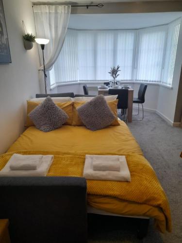 a bedroom with a large yellow bed and a dining room at Flat 4 Corner House in Doncaster