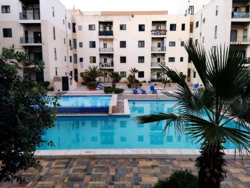 a view of a swimming pool in front of apartment buildings at In the Heart of Bugibba in St. Paul's Bay