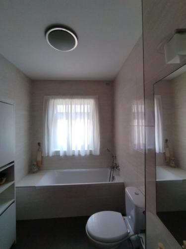 a bathroom with a bath tub and a toilet at In the Heart of Bugibba in St. Paul's Bay