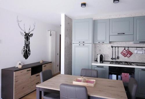 a kitchen with a wooden table in a room at IL CERVO - Cavalese Olimpiadi 2026, Dolomiti Affitti in Cavalese