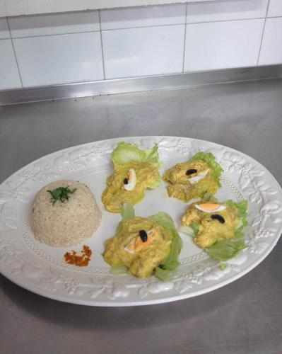 a white plate with food on it with rice at Los Jerónimos in La Tuda