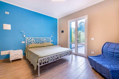 sypialnia z łóżkiem i niebieską ścianą w obiekcie Agriturismo Cascina Trevo w mieście Spotorno