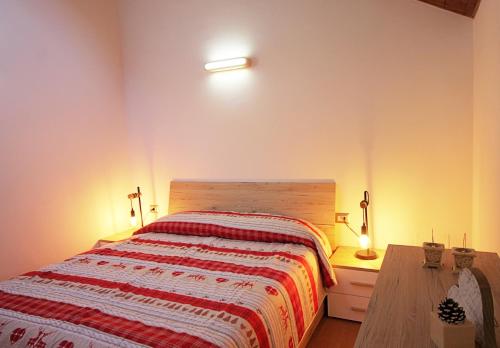 a bedroom with a bed and a wooden table at IL CERVO - mix moderno-alpino, Dolomiti Affitti in Cavalese