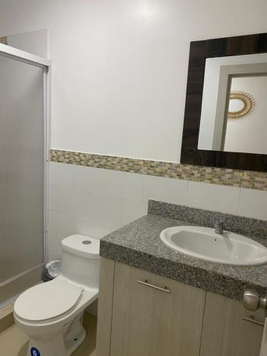 y baño con aseo y lavamanos. en Apartamento 304 en Salinas, en Salinas