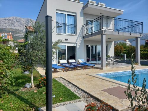 a villa with a swimming pool and a house at Villa Fidelissima in Kaštela