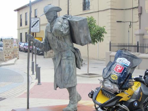a statue of a man standing next to a motorcycle at La Posada de Toribia in Val de San Lorenzo