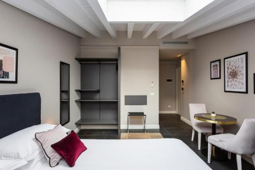 a bedroom with a bed and a table and chairs at Santarella Guest House in Milan