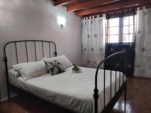 sypialnia z łóżkiem z metalową ramą i oknem w obiekcie Casa candelaria w mieście Arinaga