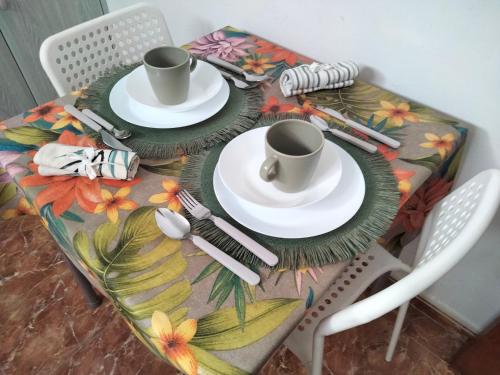 stół z dwoma kubkami i talerzami w obiekcie Casa candelaria w mieście Arinaga