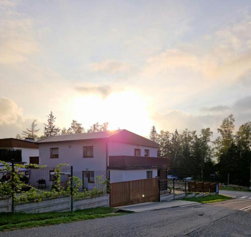 a house with the sun setting behind it at Apartamenty Alcatraz z jacuzzi in Karpacz