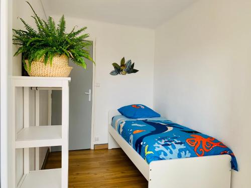 - une petite chambre avec un lit et une plante dans l'établissement Escale St Charles - 150m de la Gare, vue sur Notre-Dame de la Garde, à Marseille
