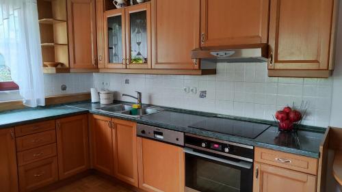 a kitchen with wooden cabinets and a stove top oven at Apartma Alda in Preserje