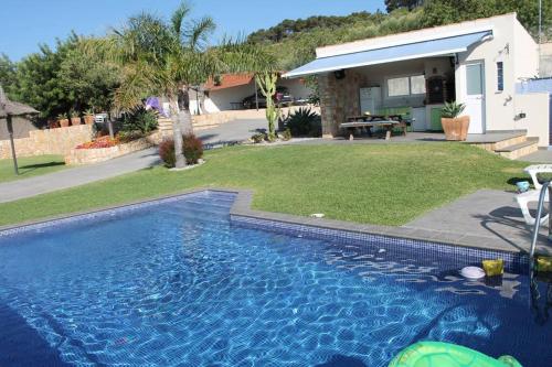 a swimming pool in front of a house at Chalet privado, con vistas al mar. in Perelló