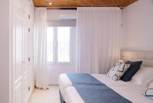 プエルト・カレロにあるCasa Lindaの白いベッドルーム(窓付きのベッド付)