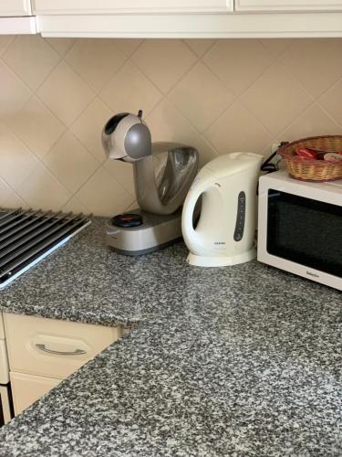 a kitchen counter with a microwave and a toaster at Apartamento Pé na Areia, Clube Nautilus, Porches in Armação de Pêra