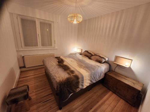 a bedroom with a large bed with two lights on it at Toffe woning dichtbij zee, bos en natuur in De Panne