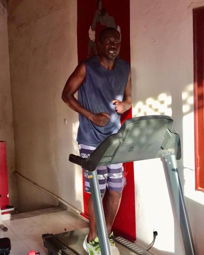 a man standing in a room on a treadmill at Maison Couleur Passion in Nianing