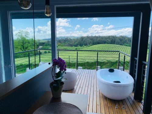a bathroom with a tub on a deck with a view at Vista Vigneti Albergo & Vino - Vale dos Vinhedos in Bento Gonçalves