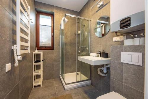 a bathroom with a glass shower and a sink at 1-Bedroom Apartment by Šventosios vartai in Šventoji
