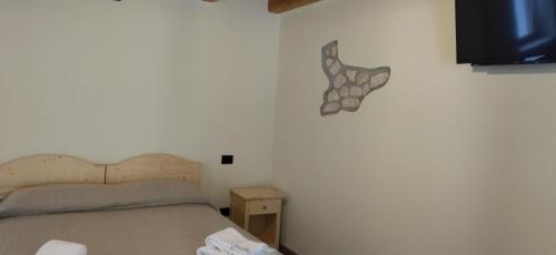 a bedroom with a bed and a tv on a wall at Agriturismo El Bocolar in Marano di Valpolicella
