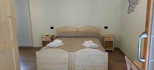 una camera con letto in legno e 2 comodini di Agriturismo El Bocolar a Marano di Valpolicella