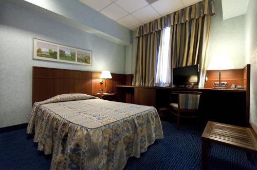 a hotel room with a bed and a television at Palace Hotel Moderno in Pordenone