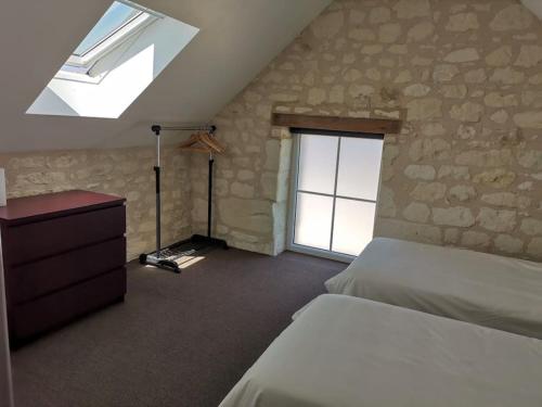 a bedroom with a bed and a skylight at Gîte des Basses Rivières in Huismes