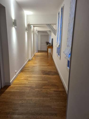 a long hallway with white walls and wood floors at Le Relais de l'endormie in Nogent-sur-Seine