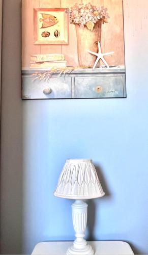 a lamp on a table with a painting on the wall at Sweet home tuscany in Bientina