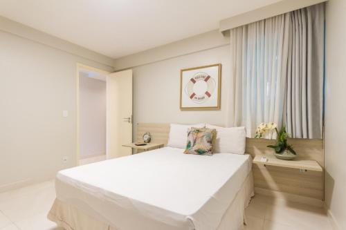 a white bedroom with a large white bed at Requinte à beira mar! Recarregue suas energias! in Angra dos Reis