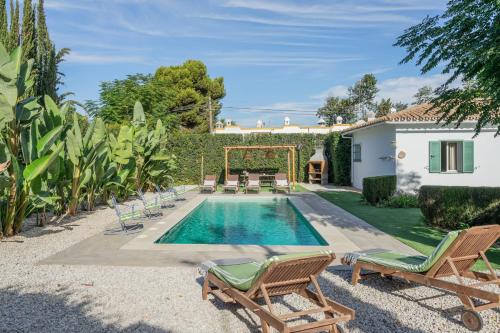 a swimming pool with chaise lounge chairs and a house at Villa en Marbella Artola&Friends in Marbella